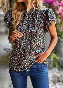 Outdoor shot of a women's short sleeve floral top made of lightweight fabric