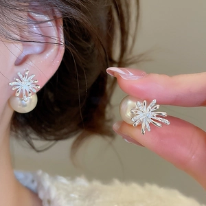 Close-up detail of gold-plated fireworks pearl earrings with zircon on silver needle