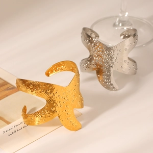 Detailed view of gold and silver starfish open bangles with unique hammered metal texture