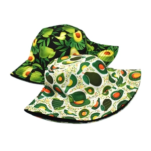 Close-up of double-sided bucket hats featuring tropical avocado and palm leaf patterns
