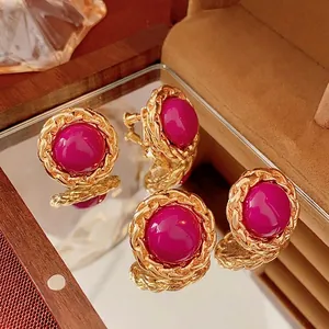 Vintage gold woven chain earrings with rose purple resin inlay in a luxury display