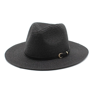 Close-up of woven straw texture and black leather band with gold buckle on sun hat