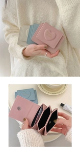 Detail showing heart-embossed PU leather wallets in pink, blue, and beige with card slots