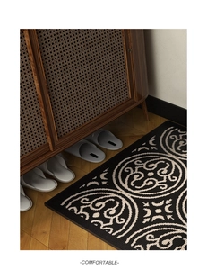 Detail of polypropylene rug with floral pattern on wood floor near vintage cabinet
