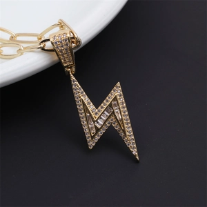 Close-up of gold lighting bolt pendant with micro-pave diamonds on thick gold chain