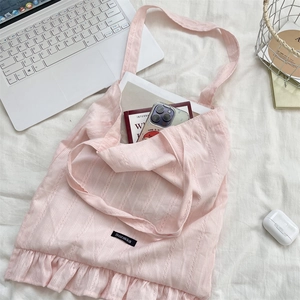 Borsa tote rosa con volant che mostra l'interno spazioso con laptop e libri di testo