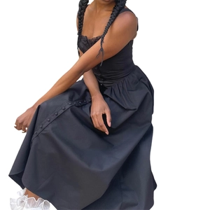 Gros plan d'une robe fleurie noire avec boutons décoratifs et détails en dentelle