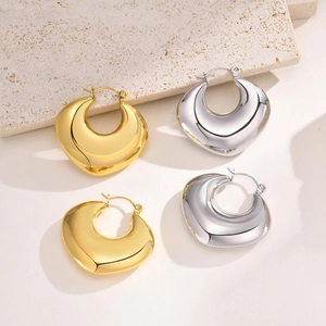 Close-up of thick hollow hoop earrings in gold and silver finish with mirror polish