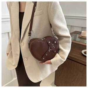 Détail du sac cœur marron foncé en similicuir avec rivets et bandoulière réglable
