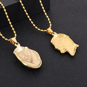 Close-up of 18K gold plated stainless steel 3D human face pendant on a bead chain