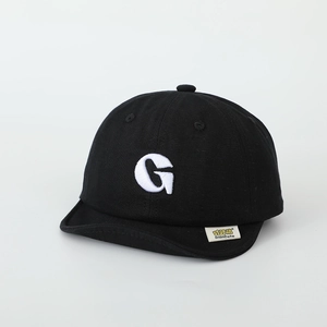 Detailed view of kids cotton baseball cap with letter G embroidery and soft brim edge