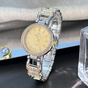 Détail macro d'une montre à quartz pour femme avec lunette diamantée et bracelet bicolore