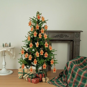 Gingerbread alphabet Christmas ornaments A-Z hanging on a decorated tree in a cozy room