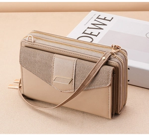 Detailed view of women's multi-layered crossbody bag with triple zippers and gold hardware