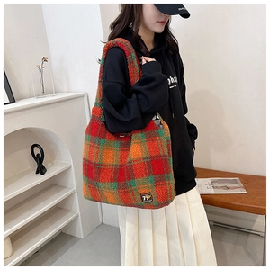 Close-up of plush plaid tote bag showing colorful teddy wool texture and logo detail