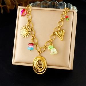 Detail of gold chain necklace with colorful bead charms and sun smiley pendant