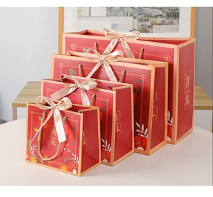 Detail of four red floral gift bags in different sizes with elegant satin bow handles