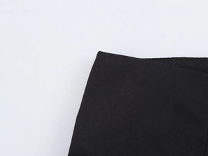 Detailaufnahme der schwarzen Stofftextur und Stickerei an dieser tropischen Freizeithose