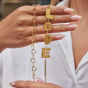 Gold layered bracelet set with heart links and hammered LOVE letters on female wrist