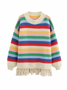 Détail d'un pull en maille rayé arc-en-ciel avec glands colorés et texture tissée douce