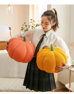 Cozy lifestyle view of large orange and yellow pumpkin plush pillows in a warm room