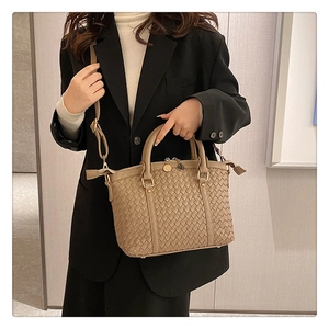 Détail du sac à main tissé montrant le motif de tressage et les finitions métalliques dorées