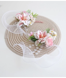 Détail d'un corsage de poignet rose pour mariée avec rubans sur un tapis tressé