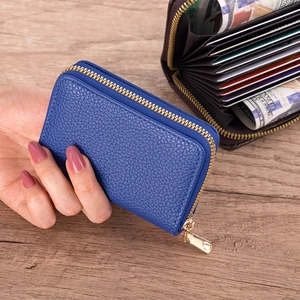 Close-up of blue lychee grain leather card holder with accordion slots and gold zipper