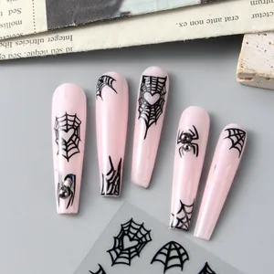 Detail of Halloween coffin nails with black spider webs and heart nail art stickers