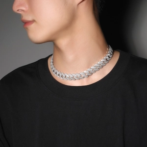 Close-up of 20mm silver Cuban link chain with inlaid zircon worn by a male model
