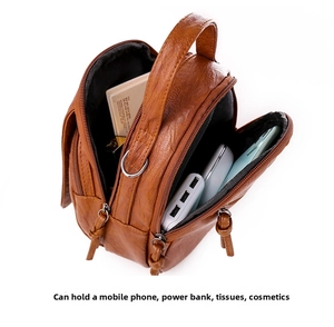 Detail view of brown multi-zip crossbody bag with compartments for phone and cosmetics