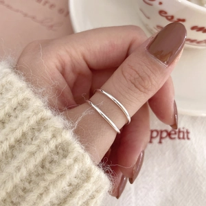 Minimalist 925 sterling silver double-layer ring with polished finish on model thumb
