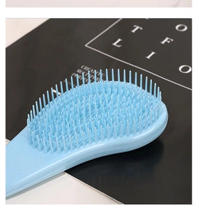 Detailed close-up showing the flexible bristles of light blue macaron massage hairbrush