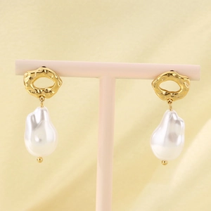 Close-up of baroque irregular pearl earrings on a display stand with silk background