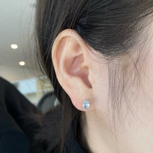Close-up of S925 sterling silver stud earring featuring an oval blue zircon on ear