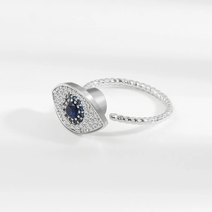 Adjustable silver spinner ring featuring a blue evil eye stone and braided metal band