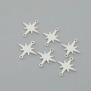Close-up of six silver star-shaped metal charms with double connector rings for DIY jewelry