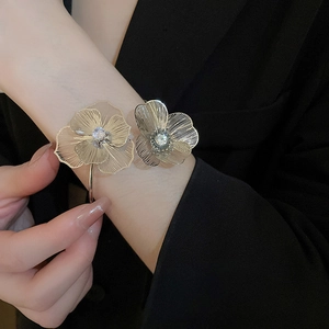 Detail of silver-tone hollow flower bracelet with sparkling crystals on a woman's wrist