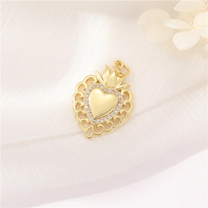 Close-up of gold heart pendant with micro-pave crystals and crown detail on fabric