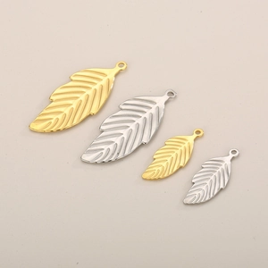 Detailed view of leaf shaped stainless steel pendants in gold and silver finishes