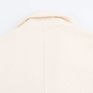 Close-up of the back collar and wool texture on an elegant cream oversized coat