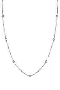 Close-up of minimalist silver snake chain necklace featuring polished metal round beads