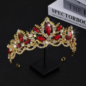Macro detail of luxury gold bridal crown with red crystals and shimmering rhinestones