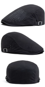 Detailed side view of black cotton newsboy cap with silver stud letter embroidery