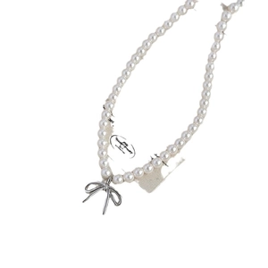 Collier de perles plaqué or élégant avec pendentif nœud argenté sur fond blanc épuré