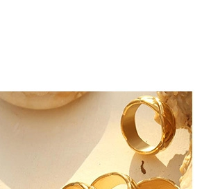 Detail of gold quilted texture ring with luxury geometric pattern on ceramic tray