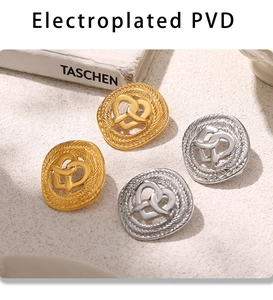 Dettaglio di orecchini vintage a nodo di cuore in oro e argento su superficie di pietra
