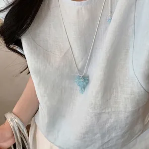 Collana minimalista con pendente a grappolo celeste su una sottile catena d'argento