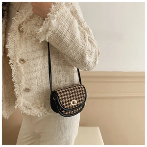 Detail der Mini-Umhängetasche mit Hahnentrittmuster und Goldverschluss auf Tweed