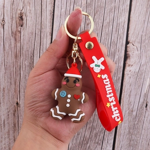Close-up of gingerbread man PVC keychain with red Christmas strap and gold metal clasp